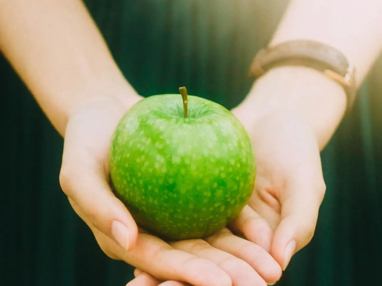 person holding green apple